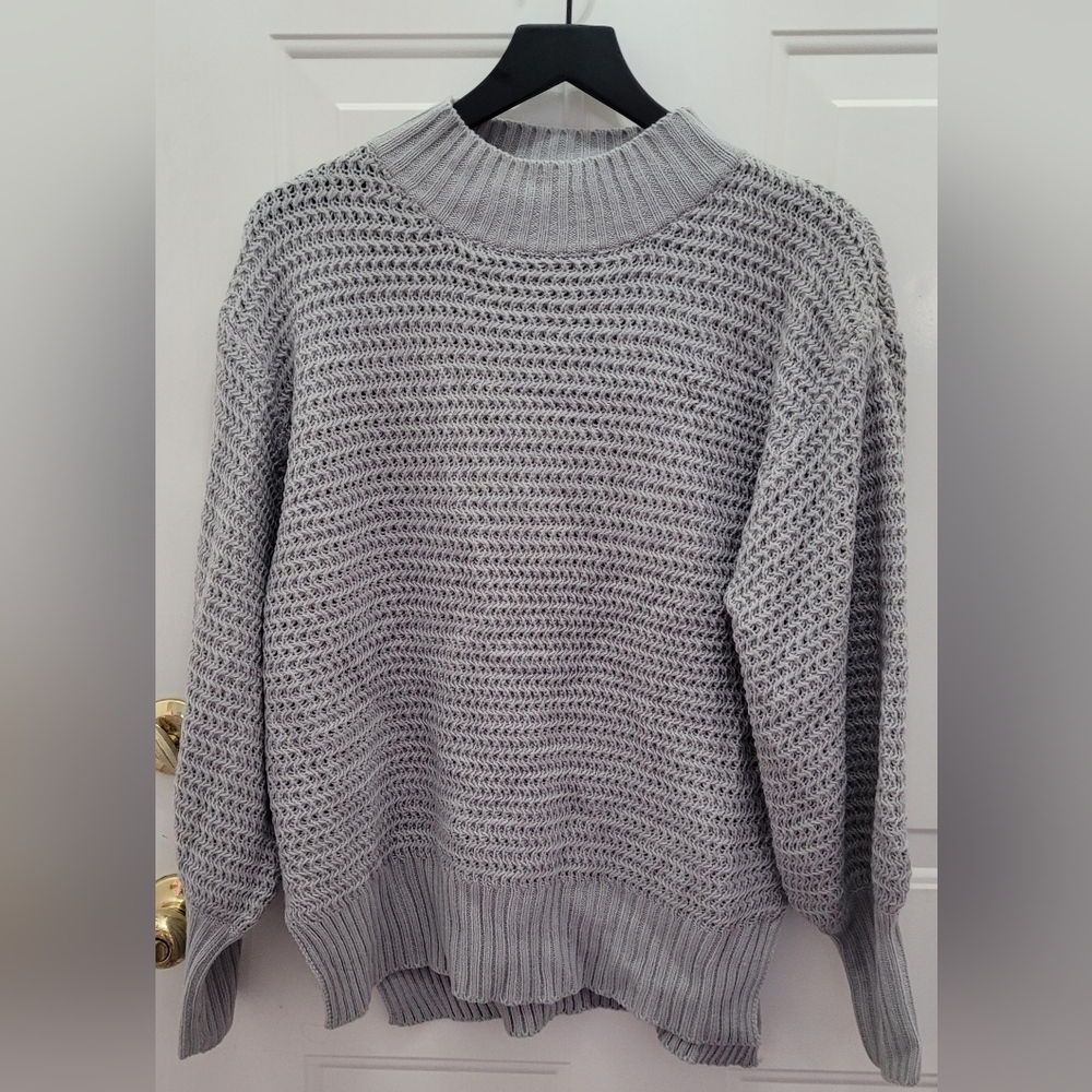 NWOT. This product is a new women's knitted sweater in a waffle-knit style.